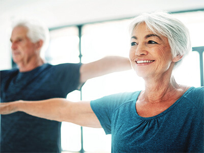 older woman and older man practicing yoga