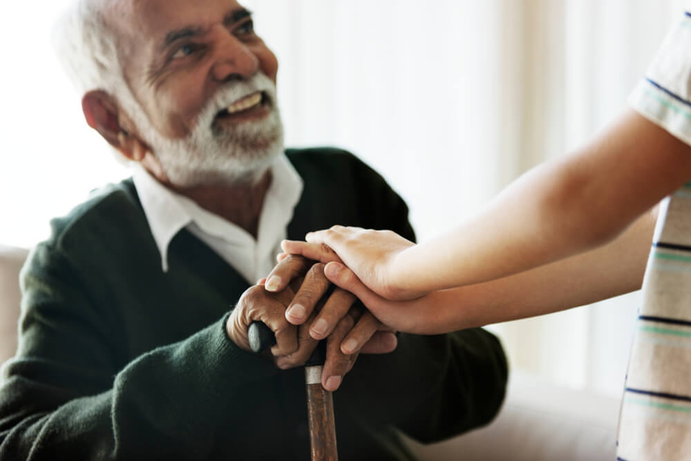 older gentleman holding hands with loved one