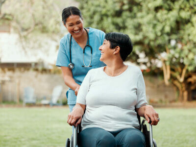 Shot of a young nurse caring for an older woman in a wheelchair