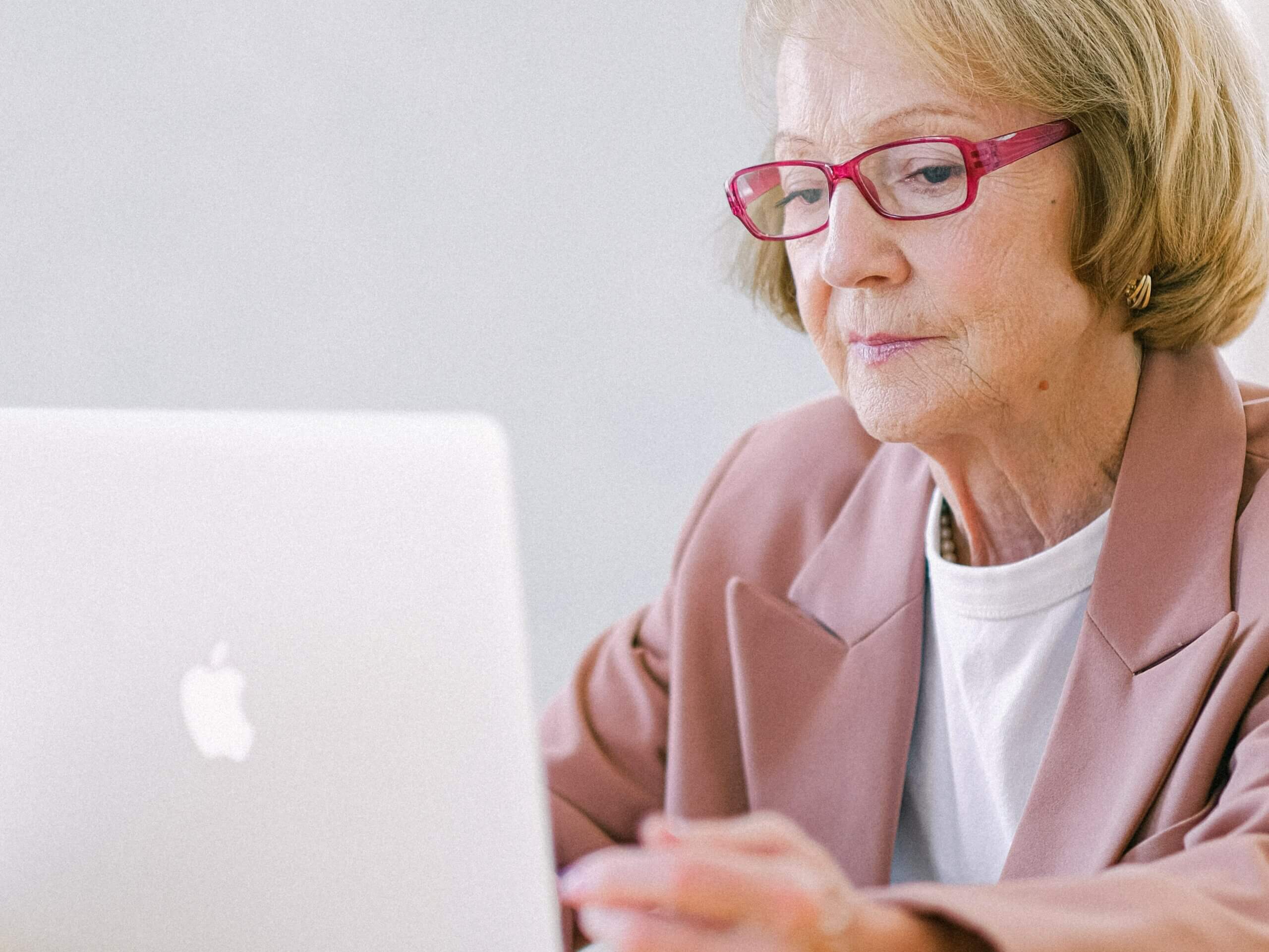 elderly woman working on a laptop